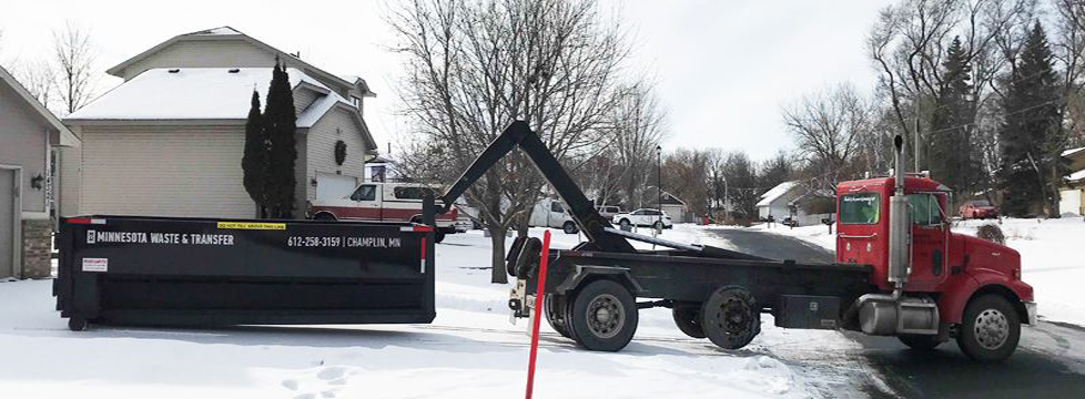 Truck dropping off dumpster